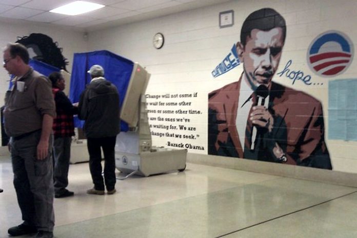 Giant Obama Mural on Polling Wall while voters vote.