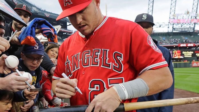 Los Angeles Angels center fielder Mike Trout autographs a bat Los Angeles Angels center fielder Mike Trout autographs a bat