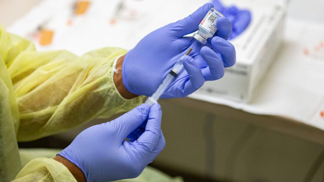 A healthcare worker prepares a Moderna COVID-19 vaccine