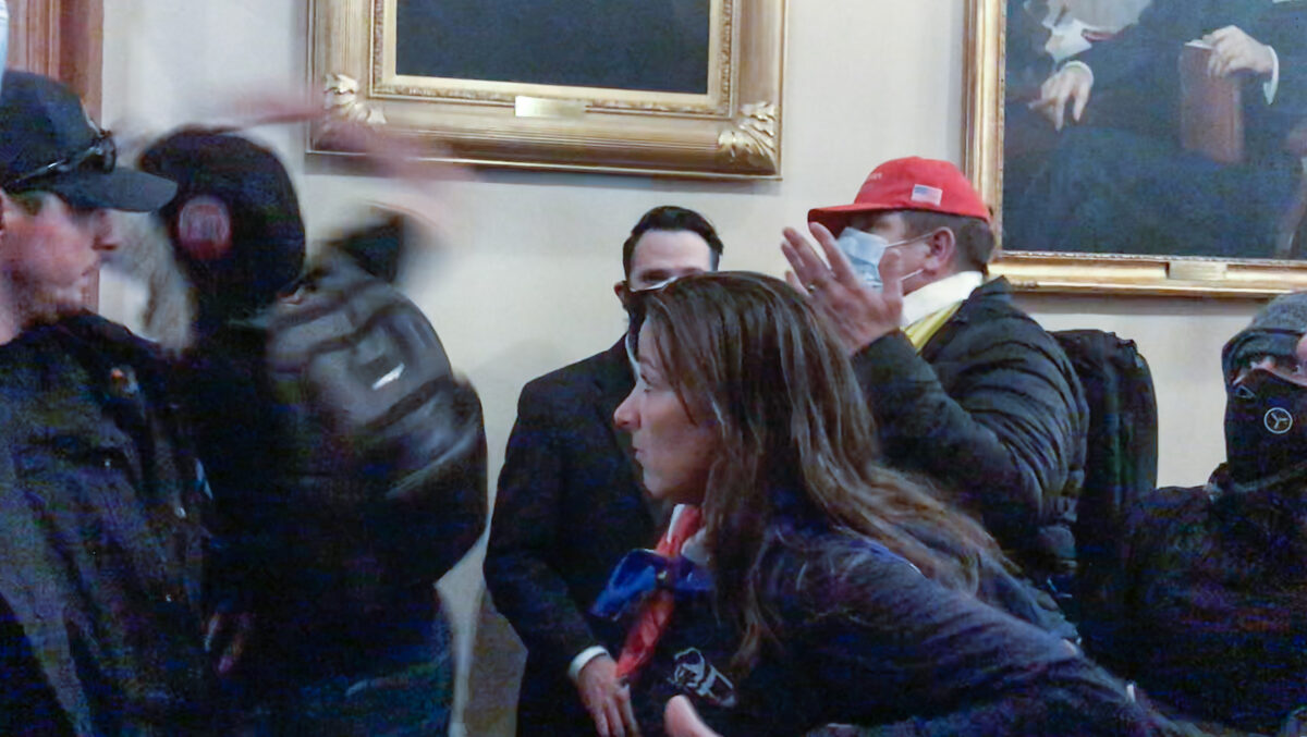Ashli Babbitt watches as rioter Zachary Alam punches the glass in the door of the Speaker’s Lobby at the U.S. Capitol on Jan. 6, 2021. (Video Still / ©Tayler Hansen)