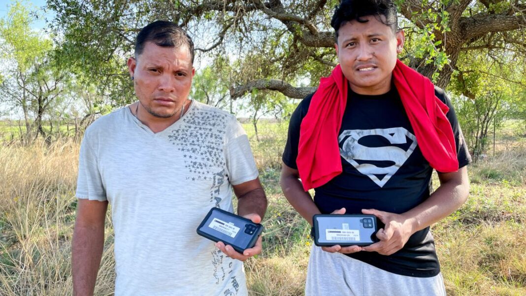 Nicaraguan nationals hold up the cell phones they received from Border Patrol