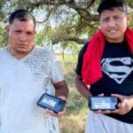 Nicaraguan nationals hold up the cell phones they received from Border Patrol
