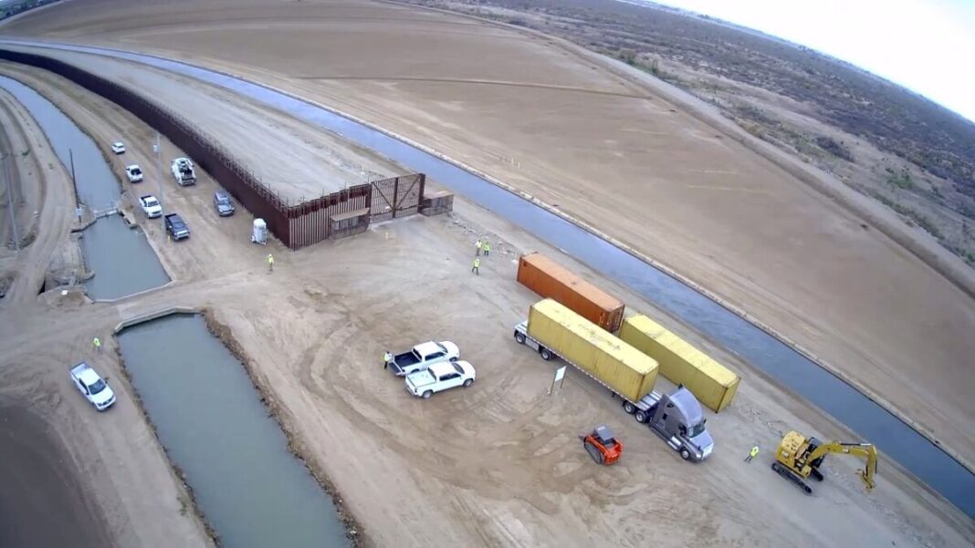 Contractors begin stacking shipping containers in border fence gaps near Yuma, AZ