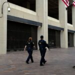 Law enforcement officers walk past the J. Edgar Hoover FBI Building