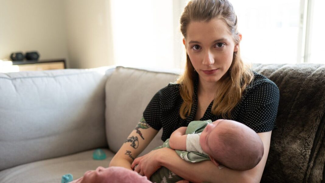 Detransitioner Daisy Strongin holds her newborn son