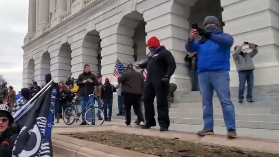 Two undercover Metropolitan Police Department officers (red and grey caps) outside the U.S. Capitol in Washington on Jan. 6, 2021.