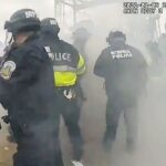 Police officers scatter after an MPD officer misfired a tear gas