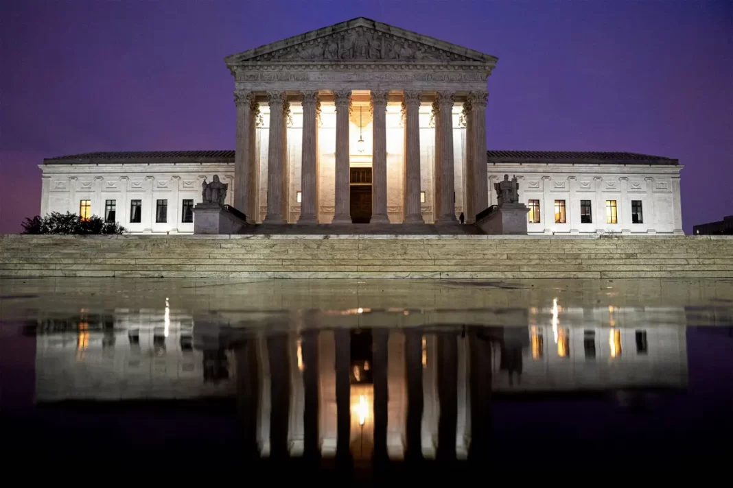 The Supreme Court is reflected in a puddle in Washington on April 5