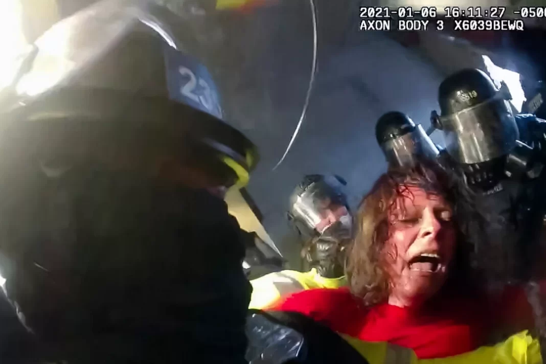 Victoria White is jostled and spun around by police in the Lower West Terrace tunnel at the U.S. Capitol on Jan. 6, 2021.