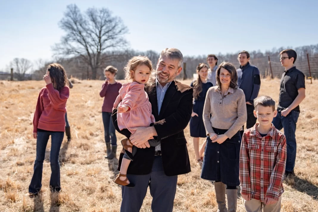 Paul Vaughn holds his youngest daughter alongside his wife Bethany Vaughn and 8 of their 11 children, in the backyard of their home in Centerville, Tenn., on Feb. 20, 2024.