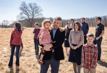 Paul Vaughn holds his youngest daughter alongside his wife Bethany Vaughn and 8 of their 11 children, in the backyard of their home in Centerville, Tenn., on Feb. 20, 2024.