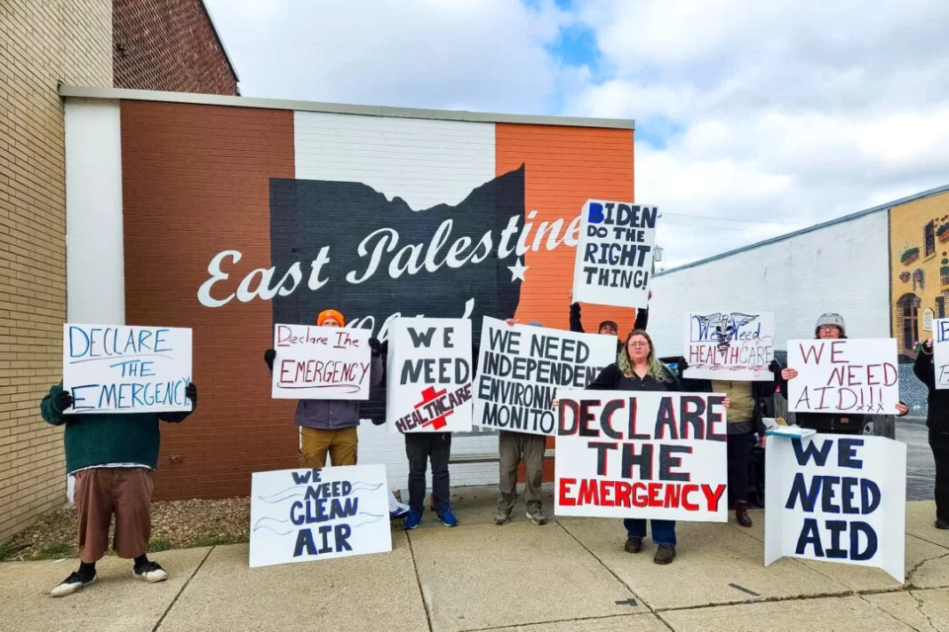 Members of a nonprofit organization working to improve environmental and health conditions in East Palestine demonstrate before President Joe Biden's visit on Feb. 16, 2024.