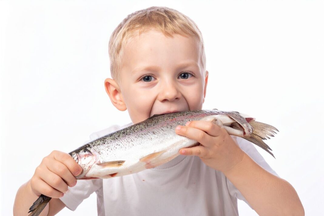 Child eating a whole fish.