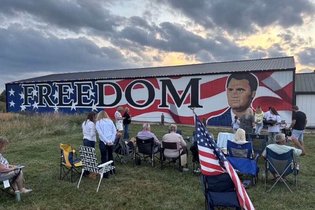 Attendees at a Charlie Kirk vigil gather around Erica Arndts's mural in Waynesville, Ohio, on Sept. 21, 2025.