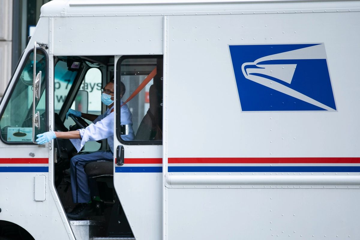 A USPS van driver parks the car on a street in New York City on Aug. 24, 2020.