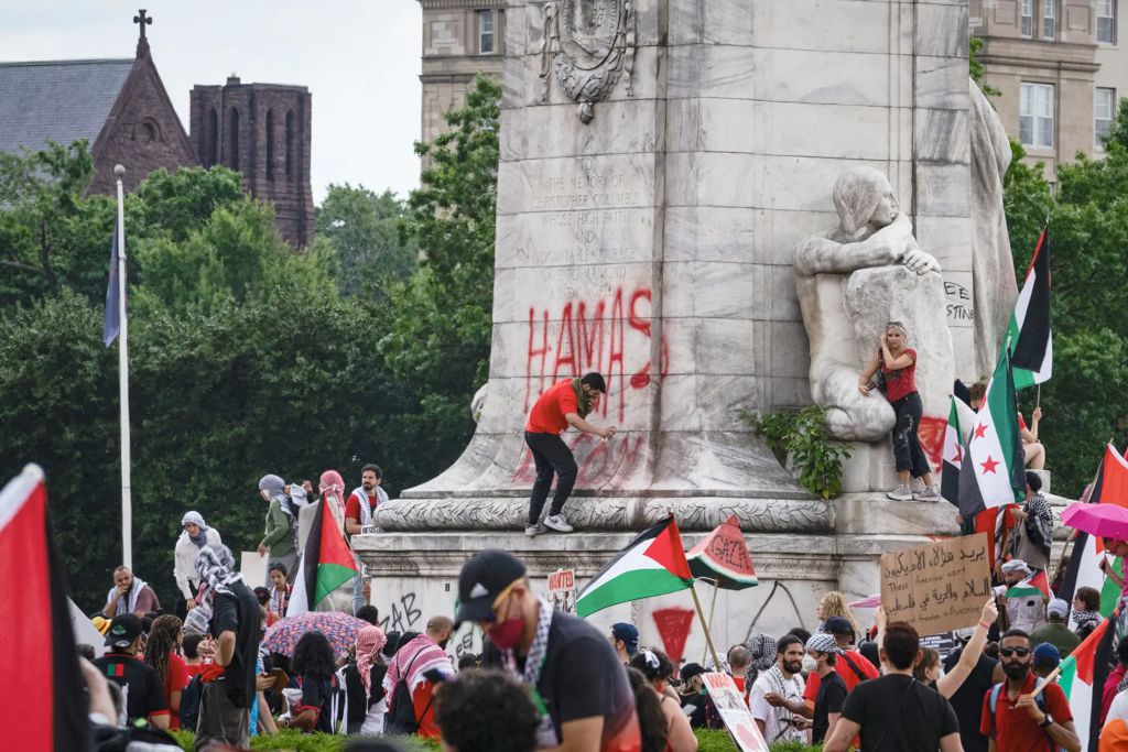 A protester sprays paint on the Columbus Fountain during a pro-Palestinian protest near the U.S. Capitol on July 24, 2024.